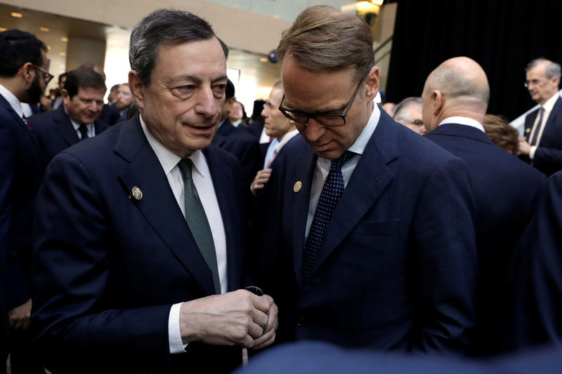 © Reuters. German Bundesbank President Weidmann and ECB President Draghi chat after G-20 finance ministers and central banks governors family photo, in Washington