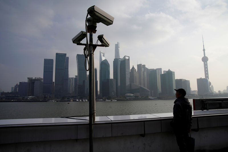 © Reuters. FILE PHOTO: A man stands on the Bund in front of Shanghai's financial district of Pudong in Shanghai