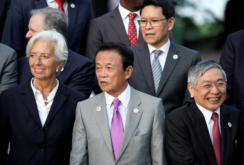 © Reuters. Japan's Finance Minister Taro Aso stands next to IMF Managing Director Christine Lagarde and Bank of Japan Governor Haruhiko Kuroda before a family photo during the G20 finance ministers and central bank governors meeting, in Fukuoka