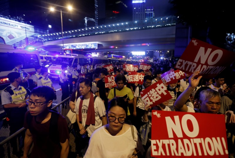 © Reuters. Manifestantes sostienen pancartas durante una protesta masiva en Hong Kong para demandar la suspensión de una propuesta Ley de Extradicón con China