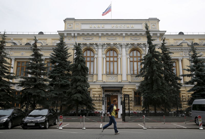 © Reuters. FILE PHOTO: A pedestrian runs past the Central Bank headquarters in Moscow