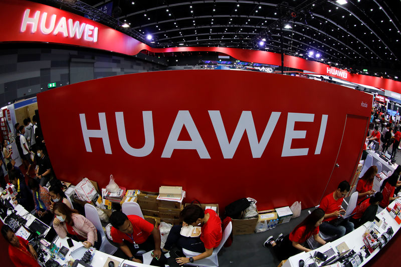 © Reuters. FILE PHOTO:Workers sit a the Huawei stand at the Mobile Expo in Bangkok