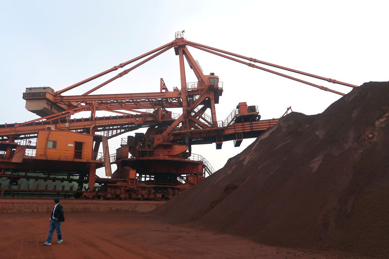 © Reuters. Man walks by the iron ore blending site at Dalian Port