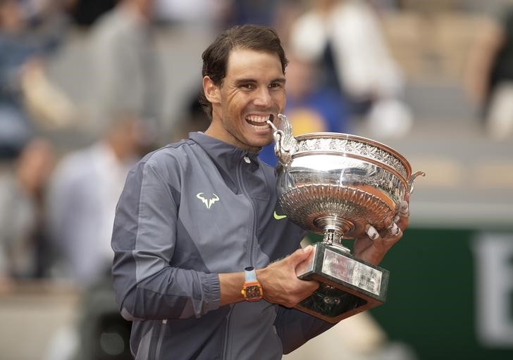 © Reuters. Rafa Nadal muerde el trofeo de campeón de Roland Garros