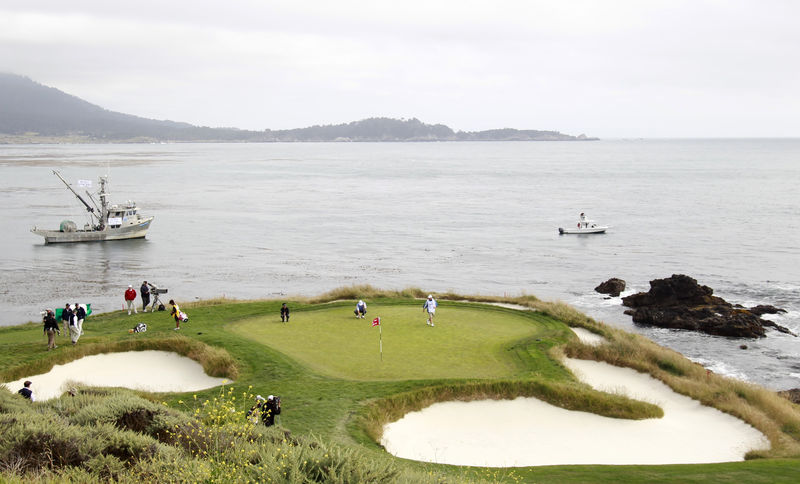 © Reuters. FILE PHOTO - Els of South Africa and Ishikawa of Japan play the seventh hole during the US Open Golf Championship in Pebble Beach