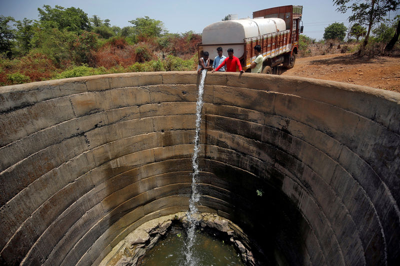© Reuters. Un pozo seco es rellenado con agua de un camión cisterna en el distrito de Thane, en el estado occidental de Maharashtra