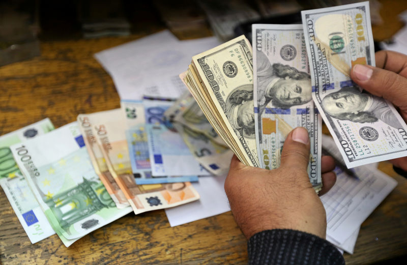 © Reuters. Un uomo conta euro e dollari