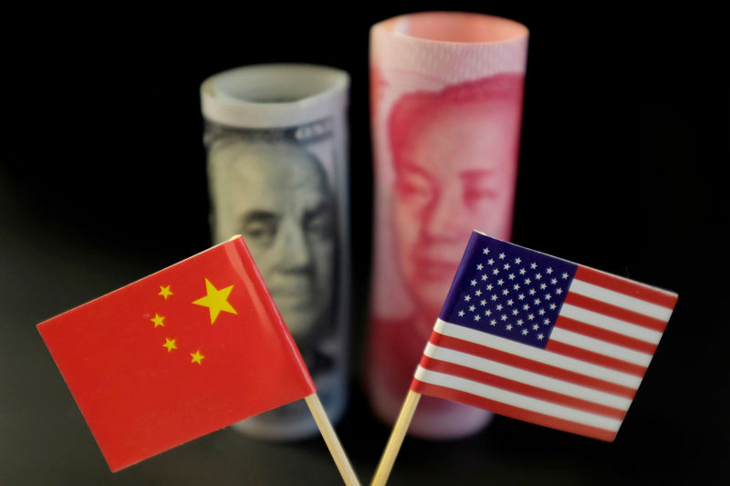 © Reuters. FOTO DE ARCHIVO: Ilustración de las banderas de Estados Unidos y China frente a un billete de dólares estadounidenses y un billete en yuan de China