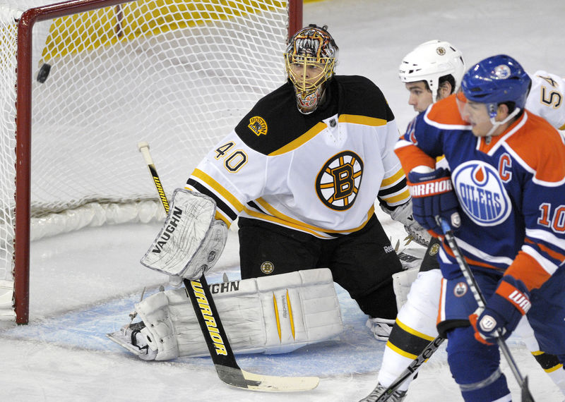 © Reuters. FILE PHOTO - Bruins' Rask watches the puck get deflected wide by Oilers' Horcoff during their NHL hockey game in Edmonton