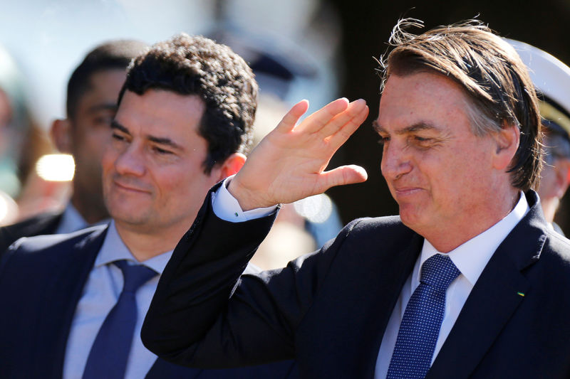 © Reuters. Presidente Jair Bolsonaro e ministro da Justiça, Sergio Moro, chegam para cerimônia em Brasília