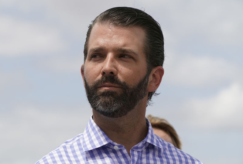 © Reuters. FILE PHOTO: Donald Trump Jr. listens to his father U.S. President Trump during visit to Lake Okeechobee in Canal Point, Florida