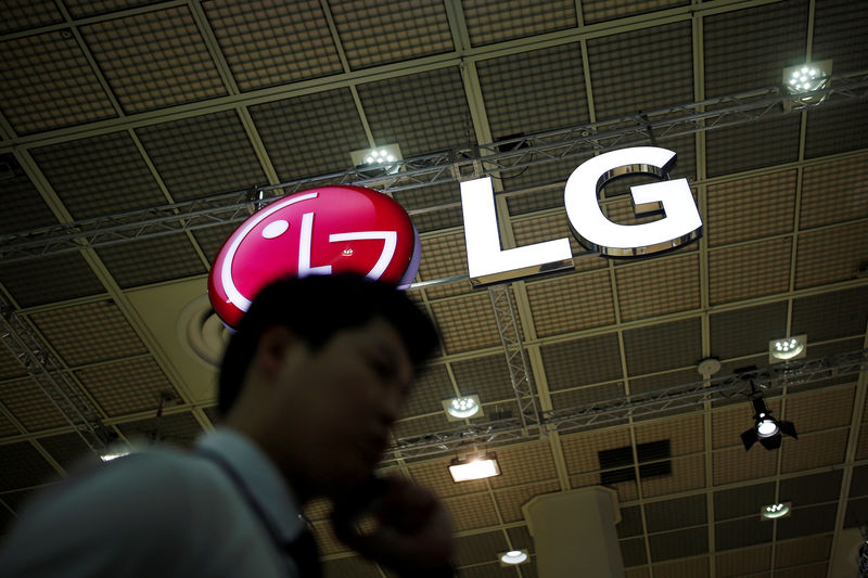 © Reuters. FILE PHOTO: A man talking on his phone walks past the logo of LG Electronics during Korea Electronics Show 2016 in Seoul