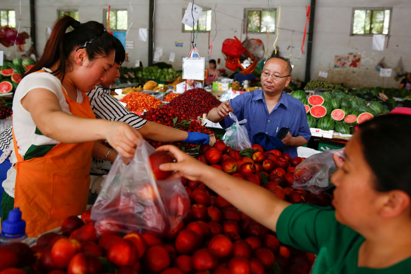 © Reuters. FILE PHOTO: People buy fruit at a fresh food market in Beijing