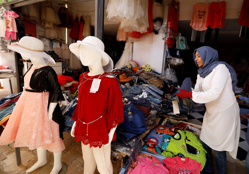 © Reuters. Una comerciante exhibe ropa a la venta en el mercado "Souk Libya" en la ciudad de Ben Guerdane, cerca de la frontera con Libia, en Túnez