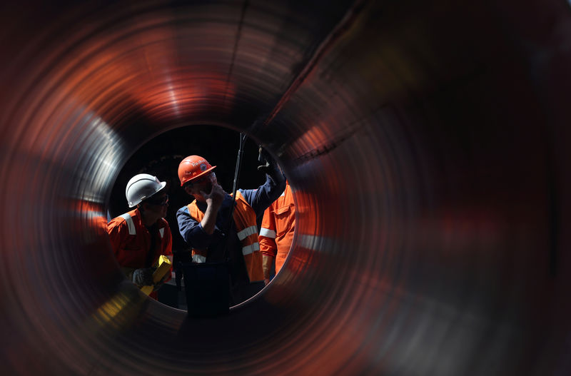 © Reuters. FILE PHOTO: Workers are seen through a pipe at the construction site of the Nord Stream 2 gas pipeline in Russia