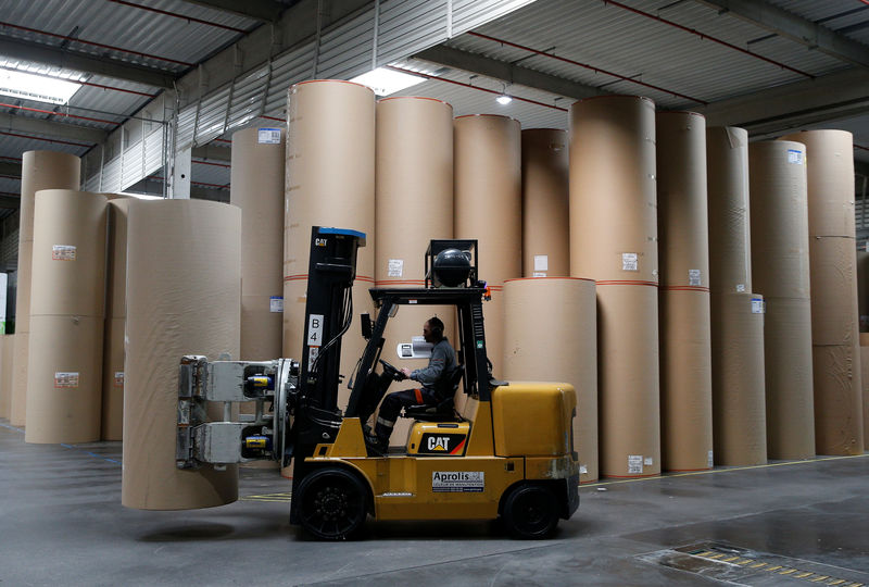 © Reuters. An employee transports a giant reel of paper at the carboard box manufacturing company DS Smith Packaging Atlantique in La Chevroliere near Nantes