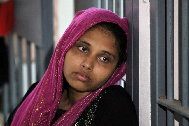 © Reuters. FILE PHOTO: A Rohingya woman is seen detained in a police station after a fishing boat carrying more than sixty Rohingya refugees was found beached at Rawi island