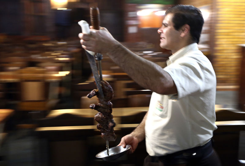 © Reuters. Garçom serve carne em churrascaria brasileira