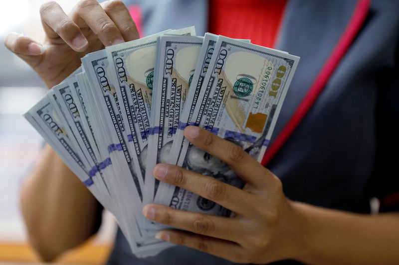© Reuters. Un uomo conta banconote da 100 dollari.