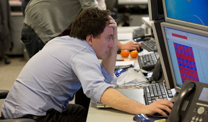 © Reuters. FILE PHOTO: A trader looks at his screen on the IG Group trading floor in London