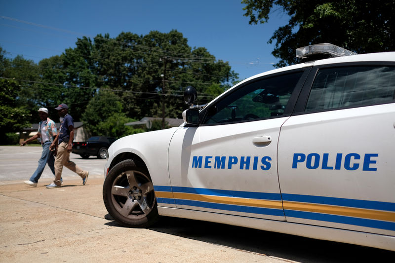 © Reuters. Homens caminham em frente a viatura de polícia em Memphis, nos Estados Unidos