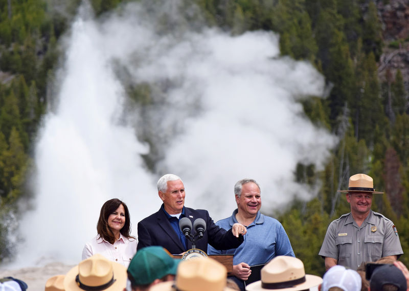 © Reuters. U.S. Vice President Mike Pence, flanked by wife Karen, Interior Secretary David Bernhardt and Yellowstone National Park Superintendent Cam Sholly, speaks in front of Old Faithful Geyser in Yellowstone National Park
