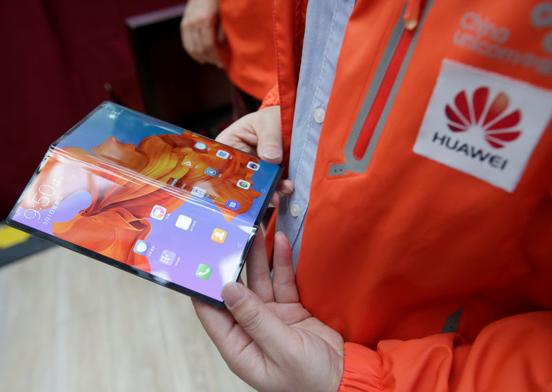 © Reuters. FILE PHOTO: A staff member shows the new Huawei Mate X smartphone with 5G network at the media center for the CPPCC and NPC in Beijing