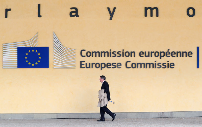 © Reuters. Un uomo passa davanti al quartier generale della Commissione europea a Bruxelles