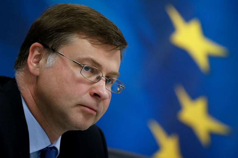 © Reuters. Valdis Dombrovskis davanti a una bandiera dell'Unione Europea