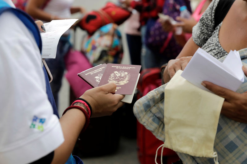 © Reuters. A Peruvian immigration officer holds Venezuelan passports ahead of a June 15 deadline for all Venezuelan migrants to have valid visas and passports, in Tumbes