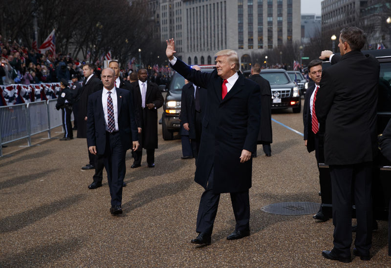 © Reuters. President Donald Trump waves as he walks near the White House in the inaugural parade in Washington