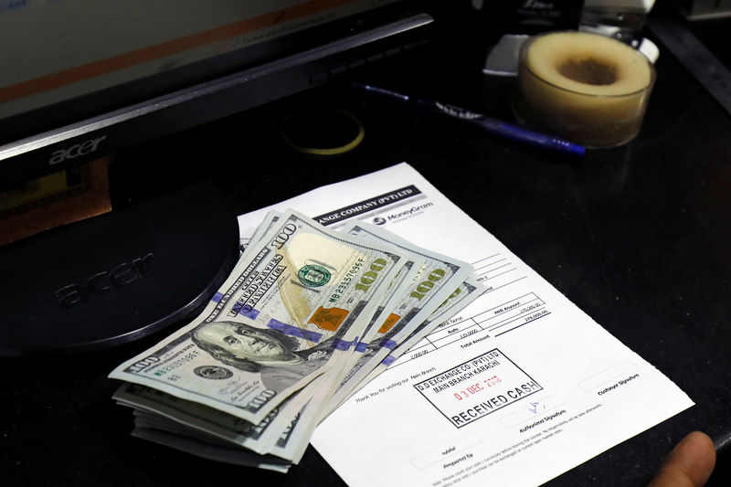 © Reuters. FILE PHOTO: U.S. dollar notes are seen on a desk at a currency exchange booth in Karachi