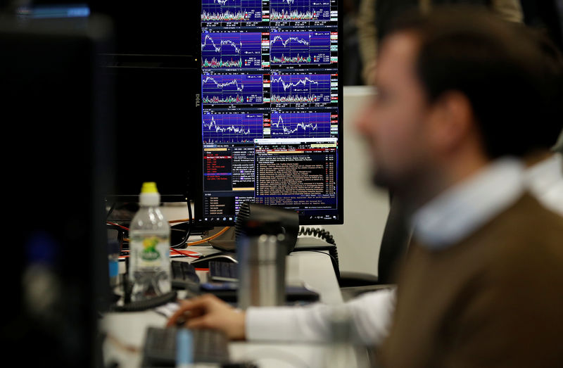 © Reuters. Financial traders work at their desks at CMC Markets in the City of London
