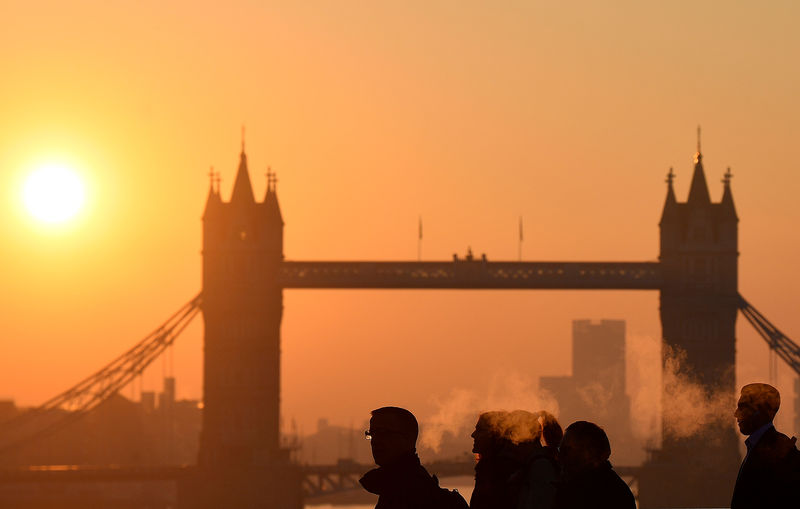 © Reuters. Workers cross London Bridge, with Tower Bridge seen behind during the morning rush hour in the city of London, Britain