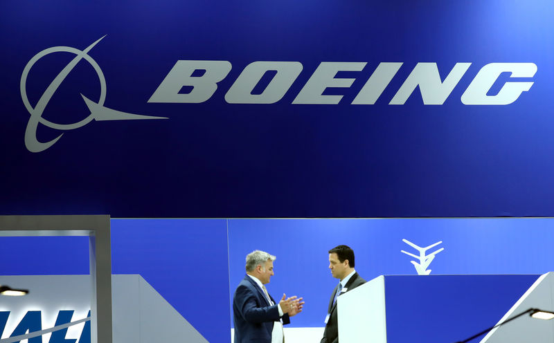 © Reuters. FILE PHOTO: Visitors talk on the Boeing stand during the EBACE at Cointrin Airport in Geneva