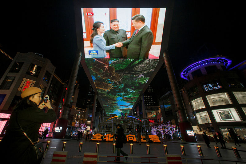 © Reuters. FILE PHOTO: A screen displays a Chinese state media CCTV news report about the meeting between Chinese President Xi Jinping and North Korean leader Kim Jong Un at a shopping mall in Beijing