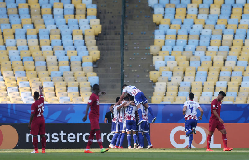 © Reuters. Jogadores do Paraguai comemoram gol contra o Catar diante de cadeiras vazias no Maracanã