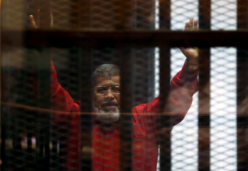 © Reuters. FOTO DE ARCHIVO. El depuesto presidente de Egipto Mohamed Mursi saluda a sus abogados desde su celda. Junio, 2015. REUTERS/Amr Abdallah Dalsh