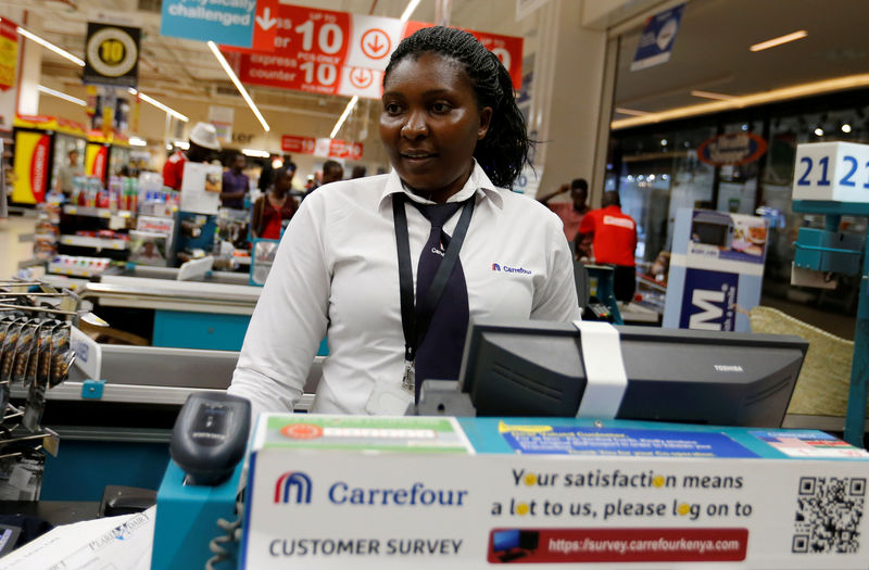 © Reuters. FILE PHOTO: A worker serves a customer inside the Carrefour hypermarket at the Two Rivers Shopping Mall in Nairobi