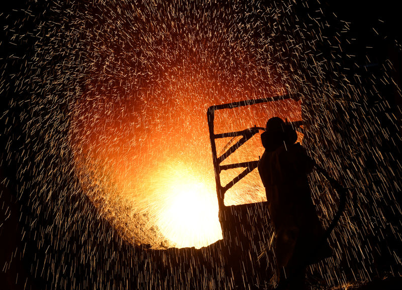 © Reuters. A steelworker cleans a steel cylinder at the plant of German steel company Salzgitter AG in Salzgitter