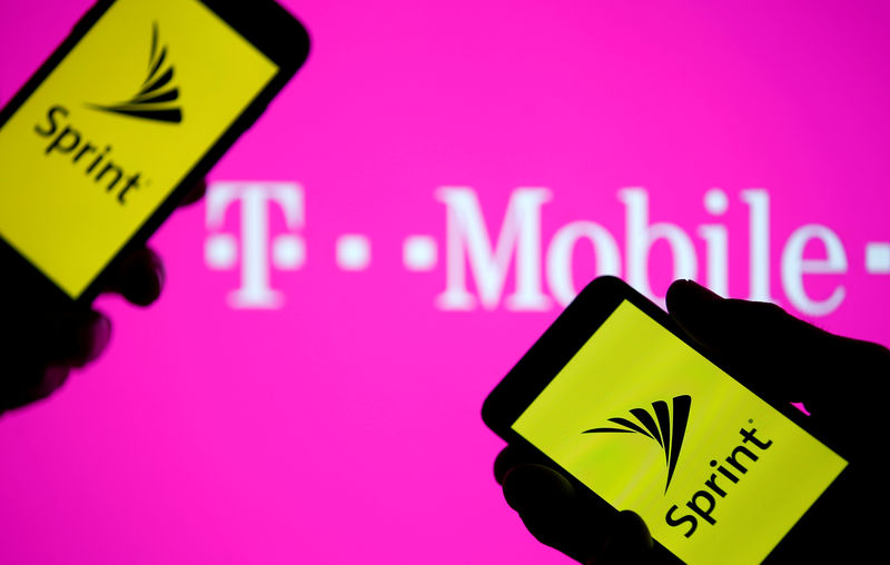 © Reuters. FILE PHOTO: A smartphones with Sprint logo are seen in front of a screen projection of T-mobile logo, in this picture illustration