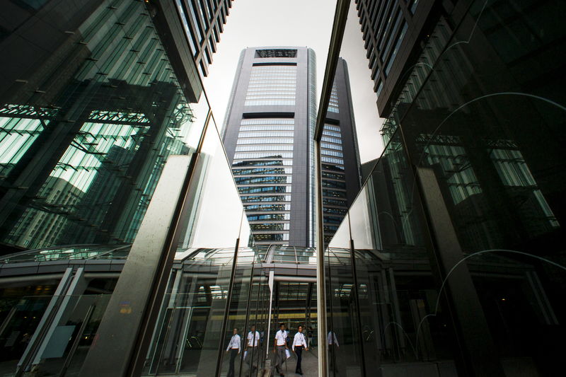 © Reuters. People walk in shadows of office skyscrapers in business district in Tokyo