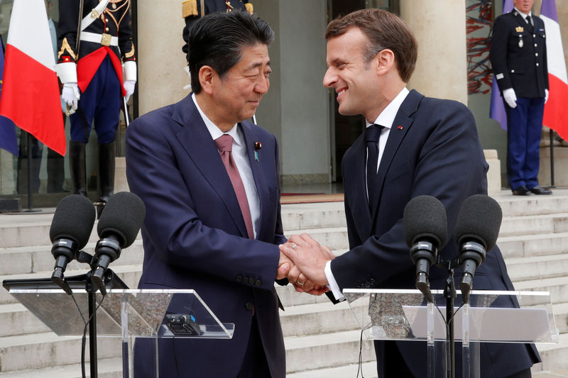 © Reuters. FILE PHOTO: French President Emmanuel Macron and Japan's Prime Minister Shinzo Abe give a joint statement to the media at the Elysee Palace in Paris
