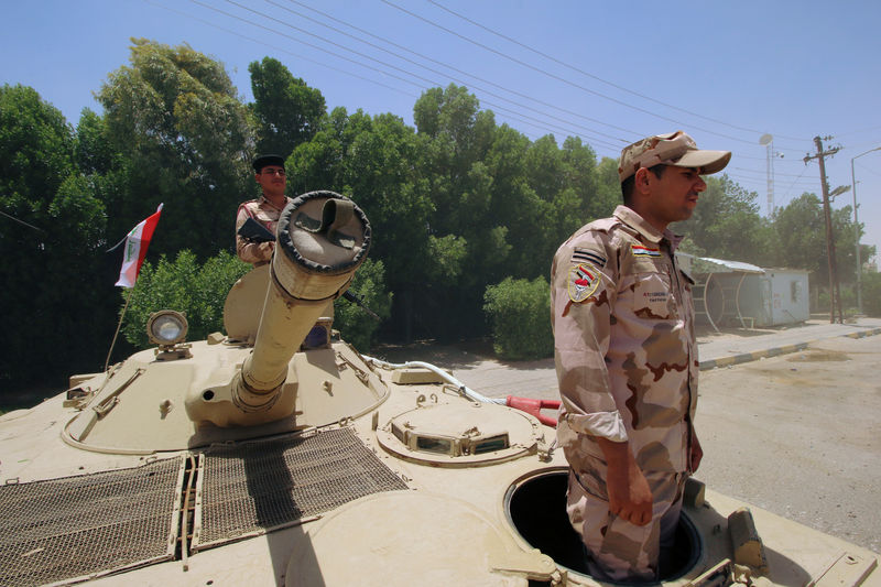 © Reuters. Soldados iraquíes en un tanque a la entrada del yacimiento petrolífero de Zubair, en Basora, Irak, el 19 de junio de 2019