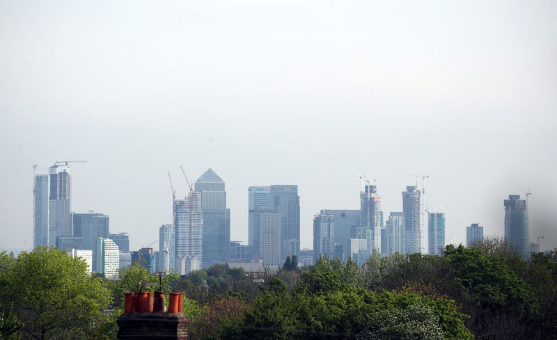 © Reuters. FILE PHOTO: The Canary Wharf financial district is seen above a residential rooftop in London