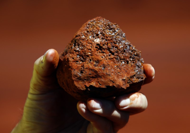 © Reuters. Trabalhador de mina segura um pedaço de minério de ferro em uma mina na região de Pilbara, na Austrália Ocidental