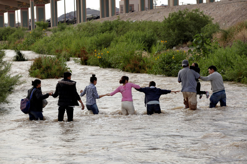 © Reuters. FILE PHOTO: Migrants from Central America form a human chain to cross the Rio Bravo river to enter illegally into the United States and turn themselves in to request asylum in El Paso, Texas, as seen from Ciudad Juarez, Mexico