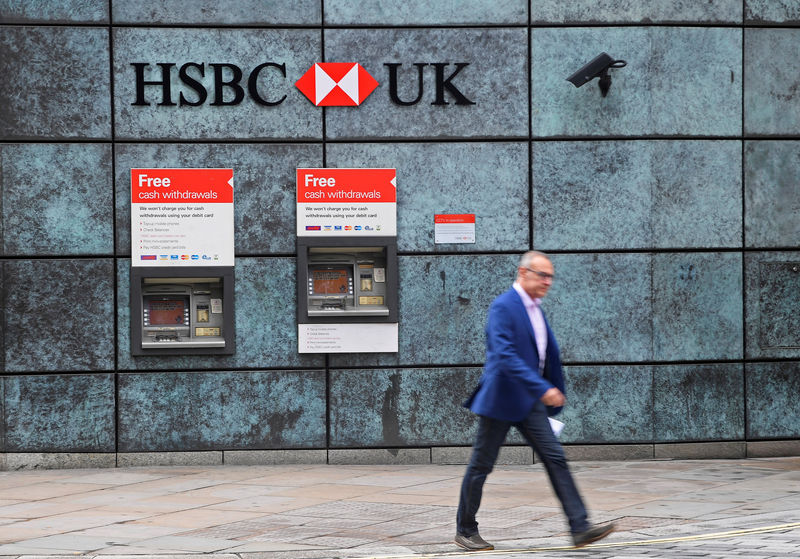© Reuters. FILE PHOTO: A worker walks past a branch of HSBC bank in the City of London financial district in London
