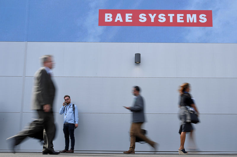 © Reuters. Trade visitors walk past an advertisement for BAE Systems at Farnborough International Airshow in Farnborough, Britain
