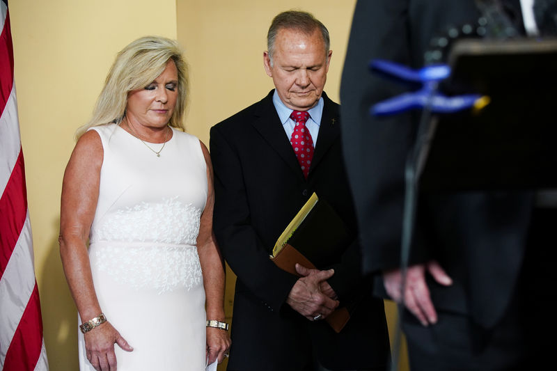 © Reuters. Roy Moore and his wife Kayla Moore pray at a news conference announcing Mr. Moore's candidacy for the U.S. Senate in Montgomery